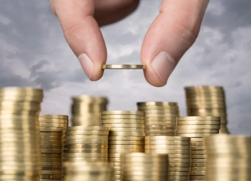 Savings, close up of male hand stacking golden coins over sky ba mercado financeiro